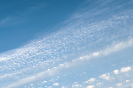 Sky with plenty of small white clouds moving diagonal direction. Nature background with copy space