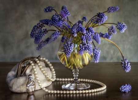 Still-life with a bouquet of colors, a handbag, pearls and spiritsの写真素材