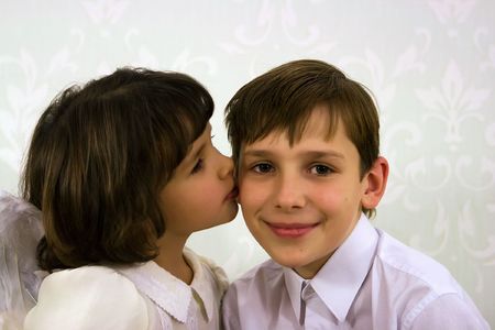 The girl kisses the senior brother on a cheekの写真素材