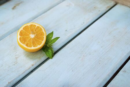 Sliced ??lemon with a leaf on a blue wooden background with empty place for textの写真素材