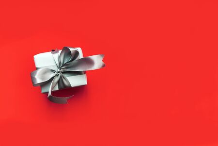 White gift box with silver flying on a red background, with an empty place for text.の写真素材