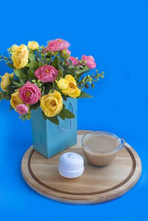 Bouquet of flowers in a paper bag on a blue backgroundの写真素材
