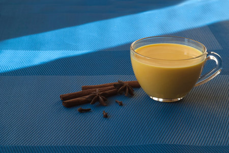 Golden milk, spices, cinnamon. Winter drink. Blue background. の写真素材