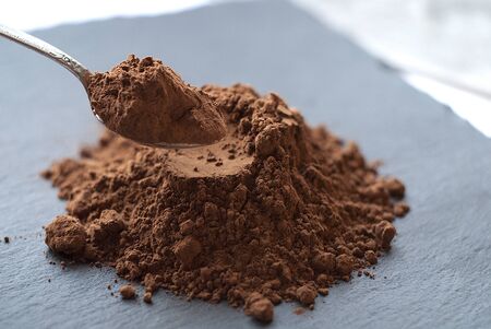 Kako powder in a spoon, scattered on a dark board,の写真素材