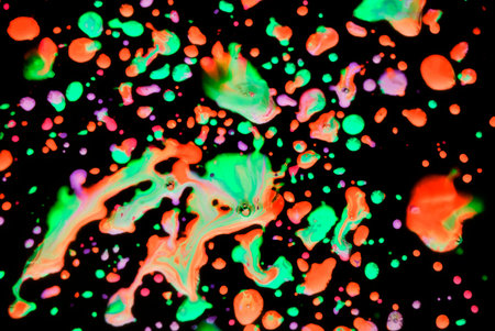 Abstraction with bright spots of orange, green, blue on a black background. Drops. Art background