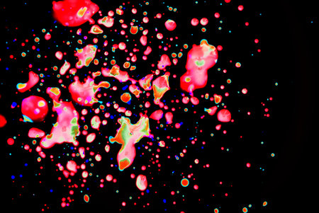 Pink green, blue drops on a black background. Abstraction