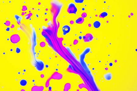 Rainbow drops and streaks of blue and pink paint on a yellow background. Art image. Abstractionの写真素材