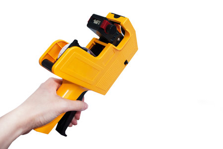 Yellow etiquette gun for price tags on a white background. Isolate
