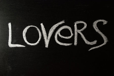 The word lovers written in white chalk on a black chalkboard