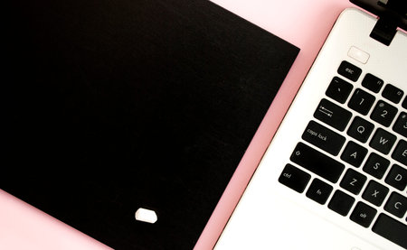 Black and white laptop keyboard, black chalk board with chalk, pink background. Top view. Flat lay....