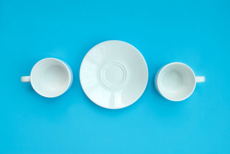 Conception good morning. Two white porcelain cups and saucers on a light claw background, top view....