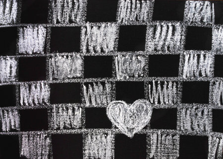 Painted chess board and white white heart on a black board