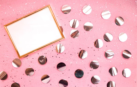 Gold frame on a pink background, confetti. Place for text. Festive background. Event. Birthday...