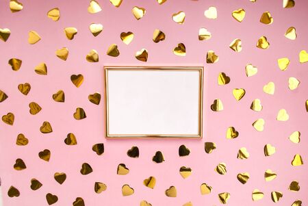 Gold frame on a pink background, confetti. Place for text. Festive background. Event. Birthday Conception. Flat lay. Top view.の写真素材