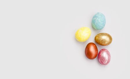 Pelamourous shiny, multi-colored Easter eggs on a white background. Golden egg. Happy Easter. Place for text. Flat lay. Top view.の写真素材