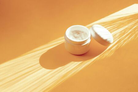 Bottle of cosmetic, coconut oil on a yellow background. Place for text. Hard shadowsの写真素材