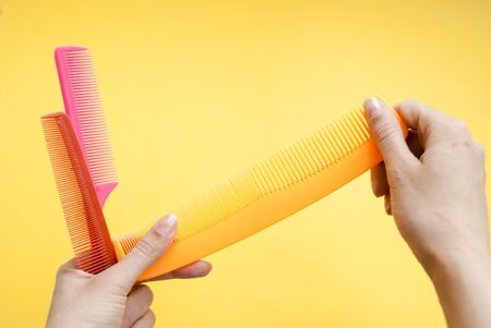 Set of multi-colored hairbrushes for hair on a yellow backgroundの写真素材