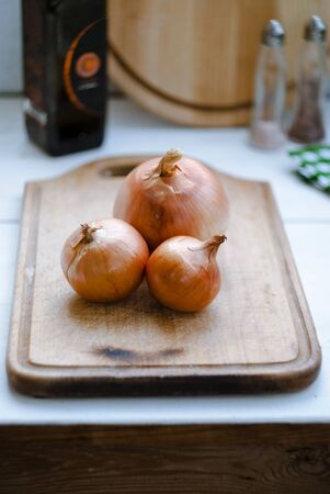 Onions on a wooden board, place for text. Close-up.の写真素材