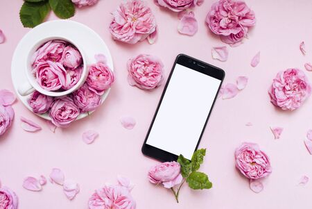Mobile phone, pink flowers pink background. Place for text. Festive background. Mock up. Postcard template. Congratulation. Morning concept.の写真素材
