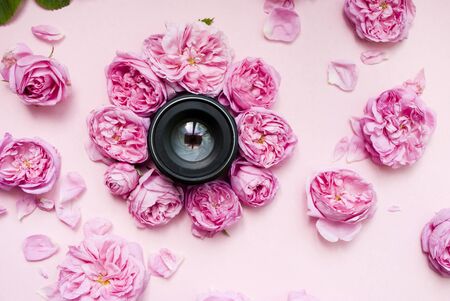 Black lens for the camera and pink flowers. Festive background. Flat lay.の写真素材