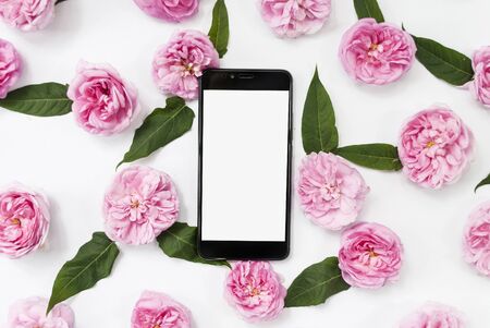 Mobile phone, pink flowers white background. Place for text. Festive background. Postcard template. Congratulation. Morning concept.の写真素材