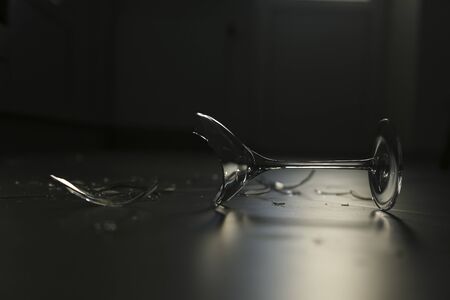 Broken wine glass lying on the floorの写真素材