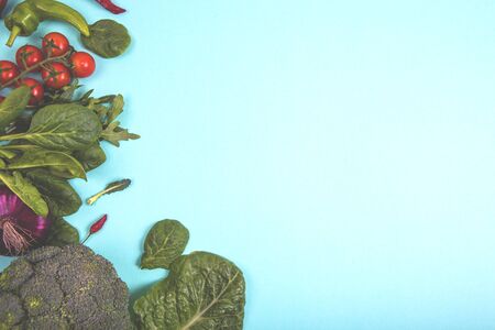 Raw organic vegetables with fresh ingredients for healthily cooking on blue background, top view. Vegan or diet food concept. Background layout with free text spaceの写真素材