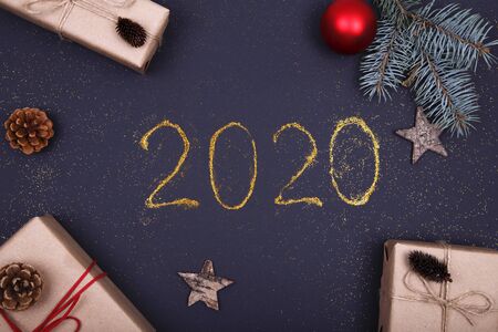 Christmas, New Year composition. Glittered number 2020, Christmas baubles, gift box, tinsel, decoration on black background. Flat lay, top view festive holiday mockup.の写真素材