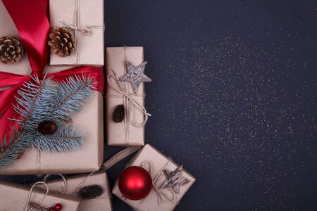 Christmas composition. Christmas gift, pine cones, fir branches, glitter on black background. Flat lay, top view, copy spaceの写真素材