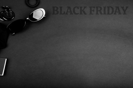 Black monochromatic flatlay on black background. Accessories and beauty equipment. Black friday sale concept. Space for textの写真素材