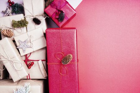 Christmas composition. Christmas gift, pine cones, fir branches, glitter on red background. Flat lay, top view, copy spaceの写真素材