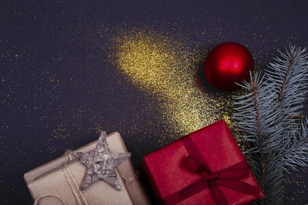 Christmas composition. Christmas gift, pine cones, fir branches, glitter on black background. Flat lay, top view, copy spaceの写真素材