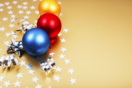Holiday background with little silver stars with Christmas balls on golden background. Festive holiday backdrop.の写真素材