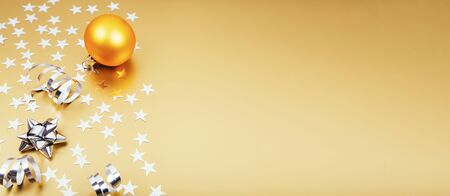 Holiday background with little silver stars with Christmas ball on golden background. Festive holiday backdrop. Bannerの写真素材