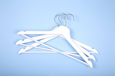 White wooden clothes hanger on blue backgroundの写真素材