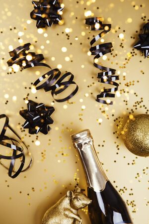 Creative flat lay composition with bottle of champagne and golden mouse and space for text on golden background. 2020の写真素材