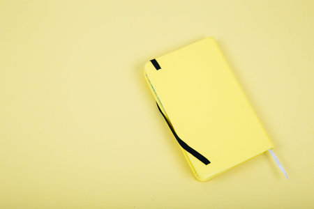 Yellow leather notebook on yellow background. Bussines concept