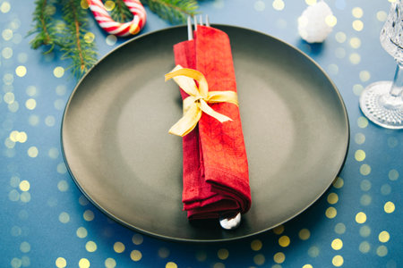 Christmas table setting with christmas decorations on blue background.