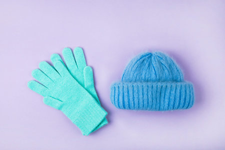 Winter woolen knitted cap and gloves on pink backgroundの写真素材