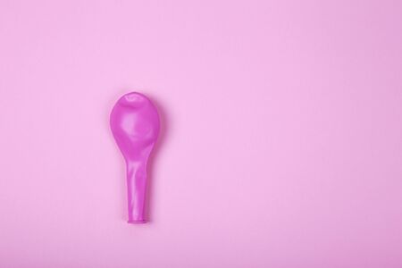 Pink rubber unblown balloons on a light pink background.の写真素材