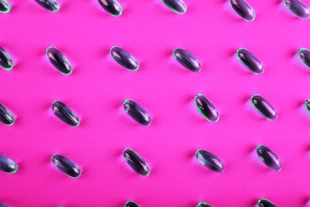 Omega 3. Fish oil capsules pattern on pink background and texture, vitamin D supplement. Close up, high resolution product. Health care conceptの写真素材
