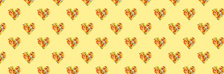 Old fashion pale multi colored candy hearts background on yellow. Bannerの写真素材