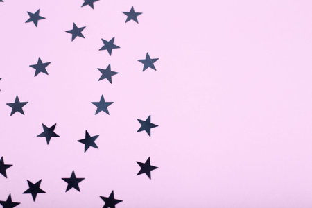 Holiday background with black stars on pink background. Space for text