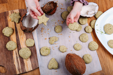 Shortbread biscuits with green tea matcha and coconut. Kids hands taking homemade buscuit