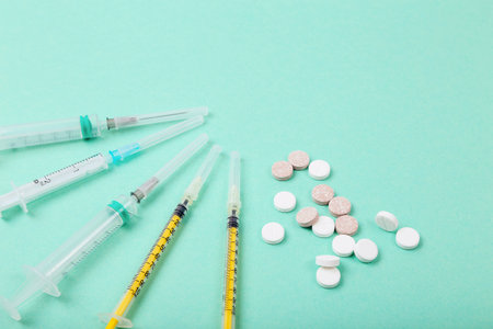 Medicines pills and syringes on color background. Healthcare, coronavirus concept