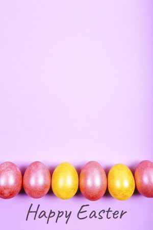 Easter eggs painted in yellow and pink colors on pink background. Happy Easter textの写真素材