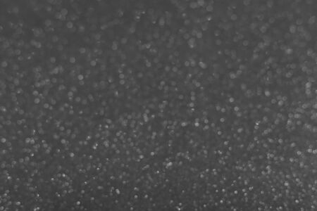 Blurred glitter vintage lights background. Silver and black. Defocused.の写真素材