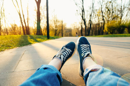 Females legs with Sneaker shoes on the ground in the park