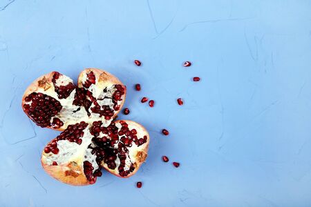 Red ripe pomegranates on blue background, copy space, top view.の写真素材