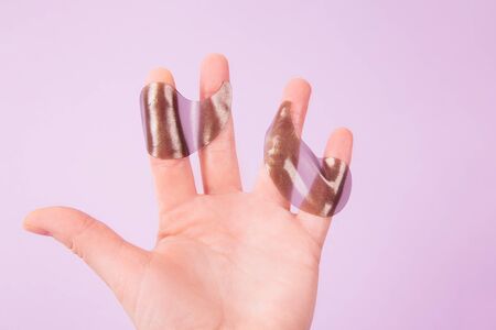 Woman's hand holds eye patches over pink backgroundの写真素材
